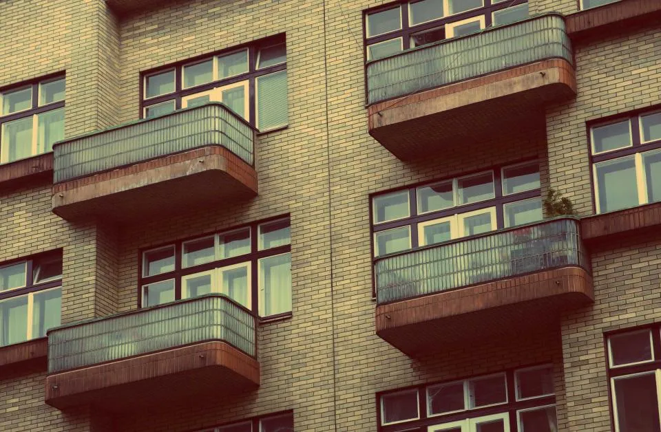 Brick apartment block with rows of balconies and windows